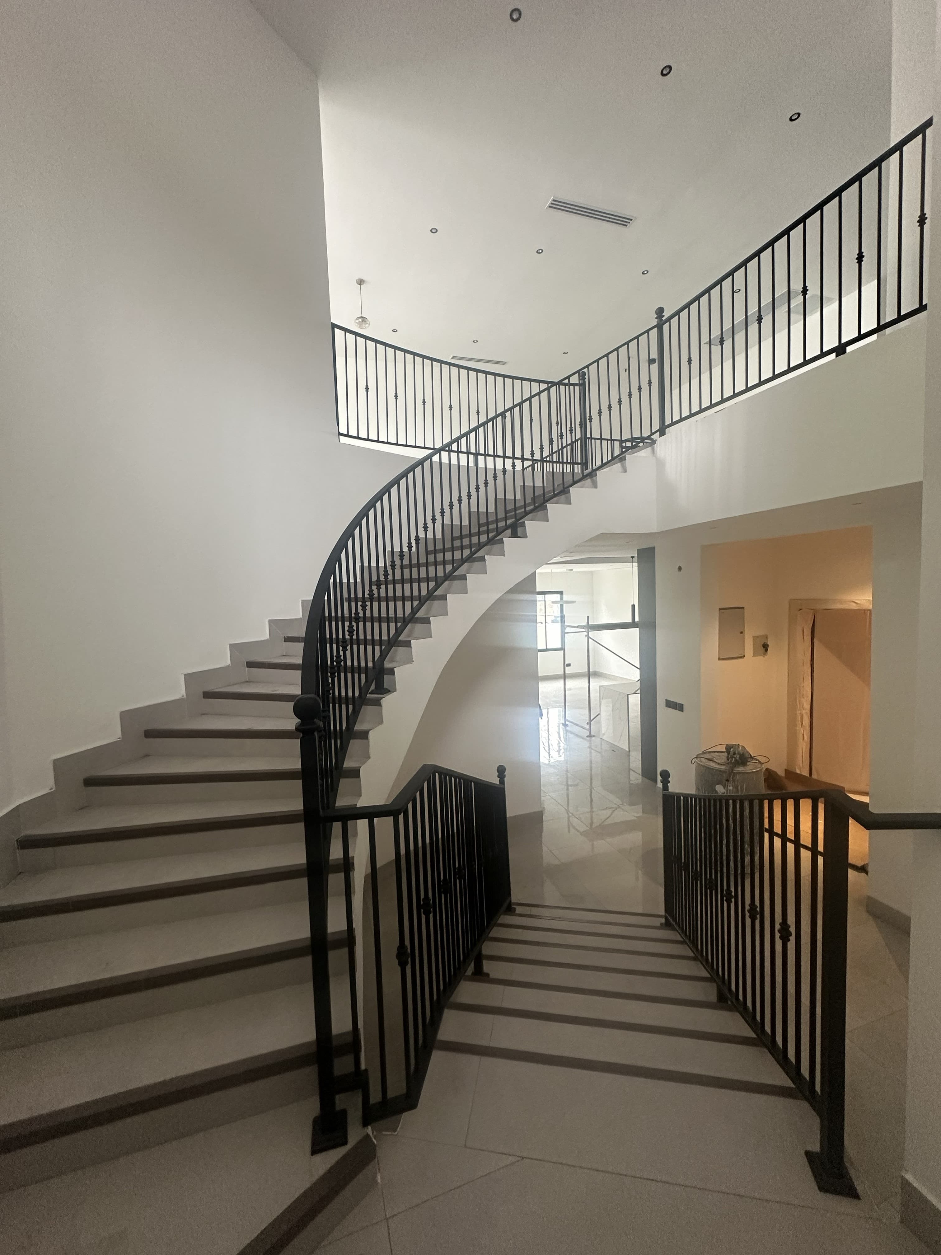 Curved staircase with wrought iron balustrade